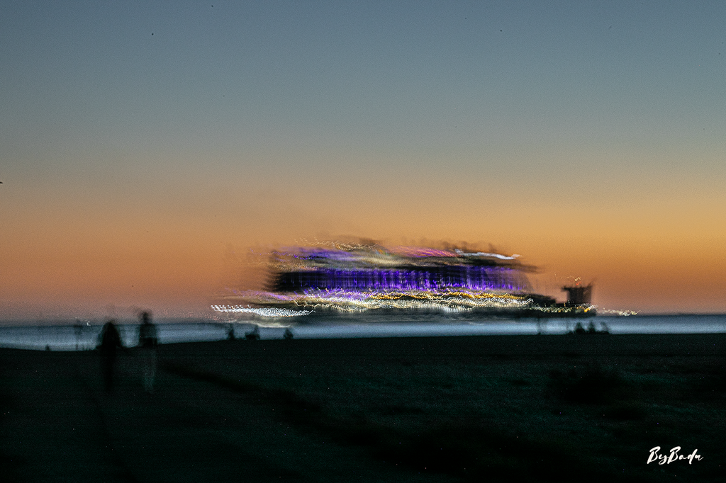 La Traversée violette — navire aux lumières violettes et blanches sous un ciel orangé, silhouettes sombres sur le rivage | Bybadr