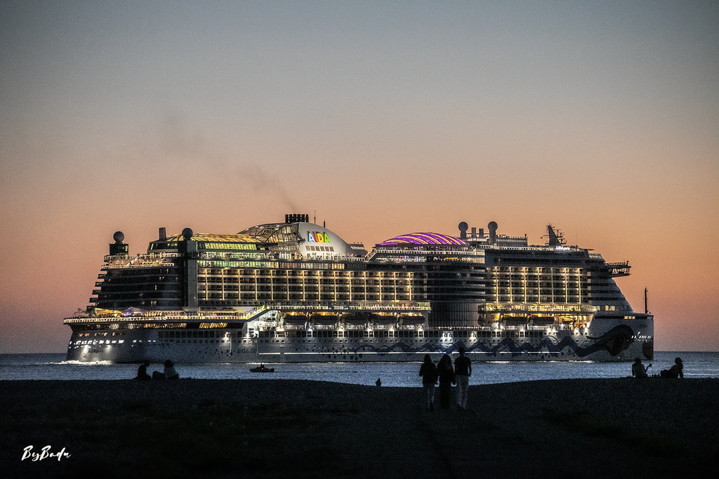 La Ville flottante — paquebot illuminé sous un ciel orangé et gris, trois silhouettes au premier plan sur le rivage | Bybadr