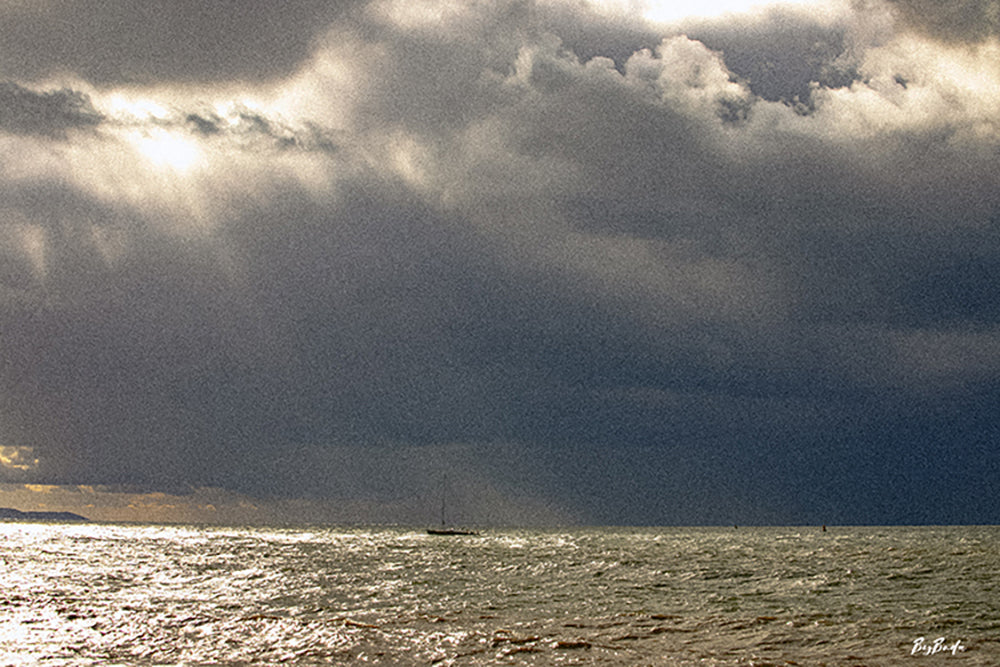 Voilier solitaire au milieu de la Manche sous un ciel d'orage, lumière dorée à l'horizon — Photographie Fine Art | Bybadr